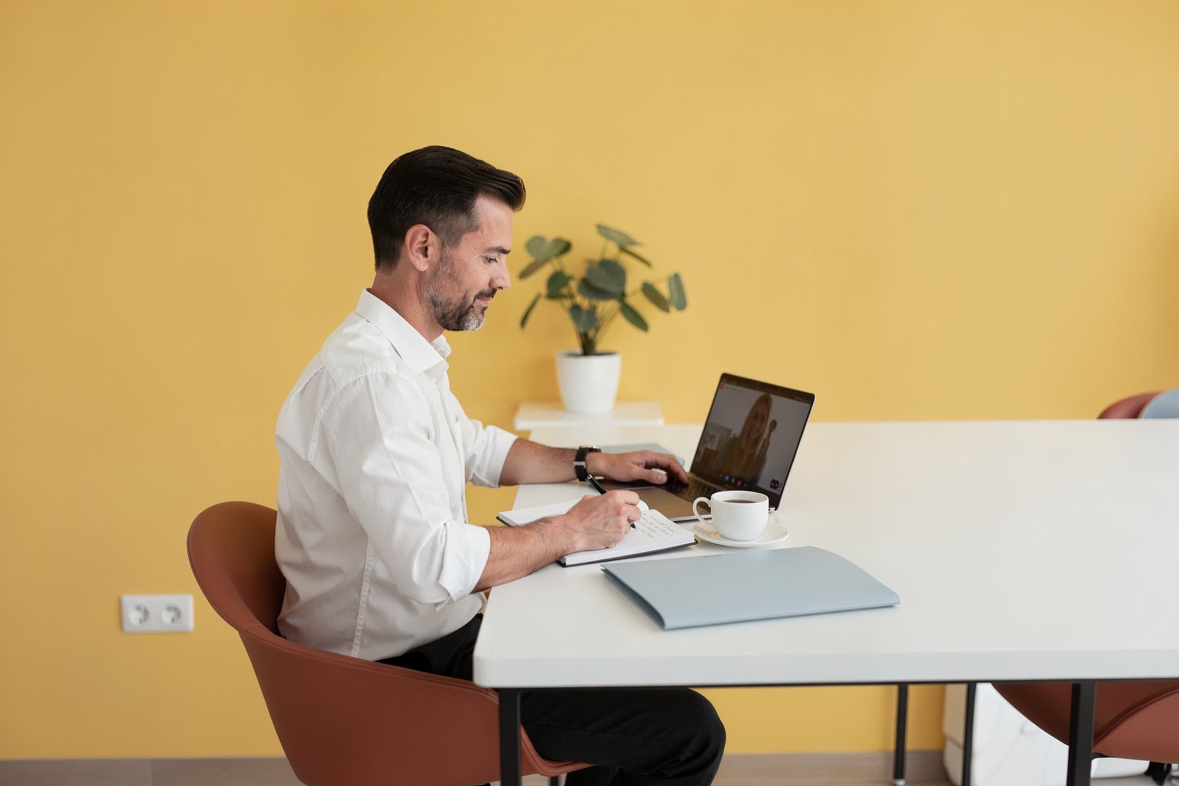 Personne prenant des notes pendant un appel en visioconférence