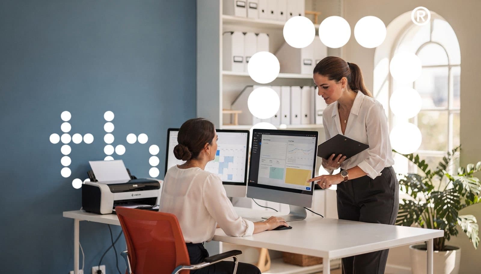 Deux collègues consultant un tableau de bord sur un écran d'ordinateur
